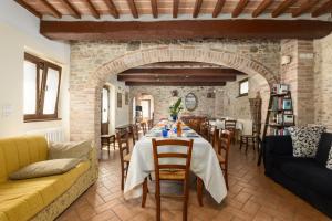 a living room with a table and a brick wall at Casale Tiziano by PosarelliVillas in Citerna