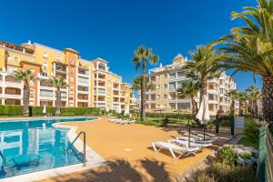 a resort with a swimming pool and palm trees and buildings at Las Dunas by Ĥ in Isla del Moral