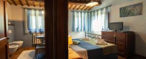 a bedroom with a bed and a tv and a bathroom at Casalantico in Corinaldo