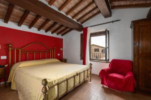 a bedroom with a bed and a red wall at Casale Tiziano by PosarelliVillas in Citerna +68 photos