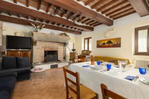 a living room with a table and a fireplace at Casale Tiziano by PosarelliVillas in Citerna