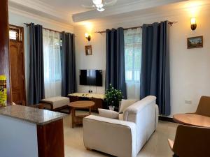 a living room with blue curtains and a couch at G4 homez in Morogoro