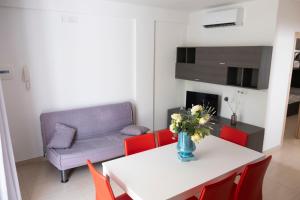 a living room with a table and a couch at Basilicata Host to Host - Le Muse in Stazione di Metaponto