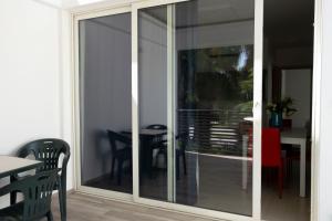 a sliding glass door in a room with a table at Basilicata Host to Host - Le Muse in Stazione di Metaponto