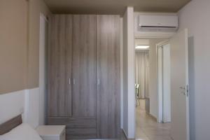 a bedroom with a large wooden cabinet in a room at Basilicata Host to Host - Le Muse in Stazione di Metaponto
