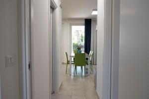 a dining room with a table and green chairs at Basilicata Host to Host - Le Muse in Stazione di Metaponto