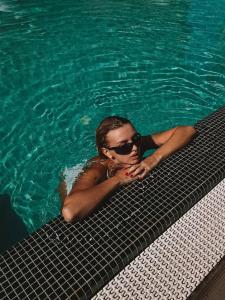 a woman laying in the water in a swimming pool at M1 Club Hotel in Odesa