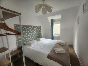 a bedroom with a bed and a ceiling fan at Le Carré Vert, appartement avec terrasse in Lamballe Armor