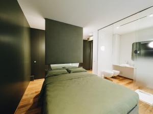 a bedroom with a green bed and a bathroom at Mafrica House in Aosta +33 photos