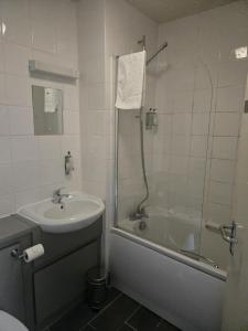 a bathroom with a tub and a sink and a shower at Rooms by the Oak in Baginton