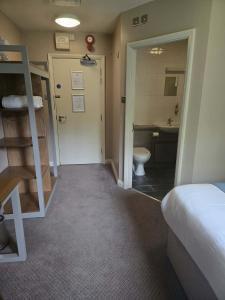 a room with a bed and a bathroom with a toilet at Rooms by the Oak in Baginton