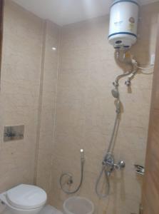 a bathroom with a toilet and a shower with a bucket on the wall at Skoon b&b homestay in Shimla