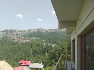 a balcony of a house with a view of a mountain at Skoon b&b homestay in Shimla