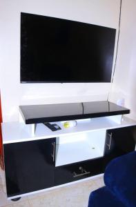 a flat screen tv on a white entertainment center at Atié Haven in Lira