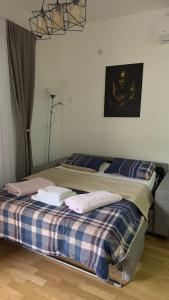 a bed in a room with towels on it at Bozovic Apartman 2 in Budva