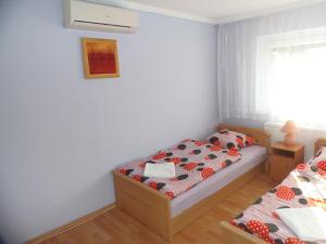 a bedroom with two twin beds and a window at Rose Vip Apartman in Hajdúszoboszló