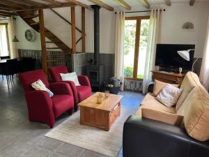 a living room with two couches and a tv at Liabaquet Gîtes in Sarlande