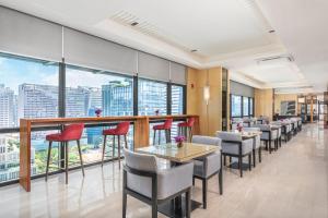 a restaurant with red chairs and tables and windows at Seda Bonifacio Global City Manila in Manila