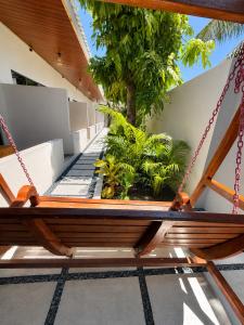 a swing on the porch of a house at Isola Alifu in Feridhoo