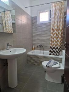 a bathroom with a sink and a toilet and a tub at Harry's Apartment in Lefkimmi +17 photos