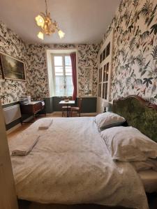 a bedroom with a large bed with floral wallpaper at 13 Bohemian Bienvenue B&B in Pontrieux