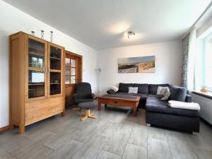 a living room with a couch and a chair at Frey - Ferienhaus über zwei Etagen mit Terrasse in Eggebek