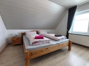 a bedroom with a bed with pillows and a window at Frey - Ferienhaus über zwei Etagen mit Terrasse in Eggebek