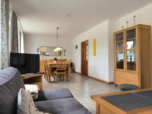 a living room with a couch and a dining room at Frey - Ferienhaus über zwei Etagen mit Terrasse in Eggebek