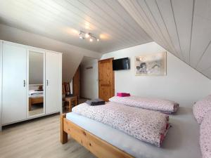 a bedroom with two beds and a mirror at Frey - Ferienhaus über zwei Etagen mit Terrasse in Eggebek +15 photos