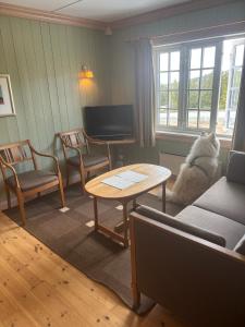 a dog sitting in a living room with a table at Nyt høsten på Toppen av Hafjell in Øyer