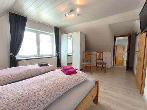 a bedroom with two beds and a table with a chair at Frey - Ferienhaus über zwei Etagen mit Terrasse in Eggebek