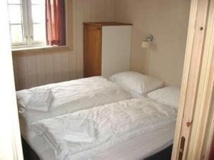 a bedroom with a bed with white sheets and a window at Nyt høsten på Toppen av Hafjell in Øyer