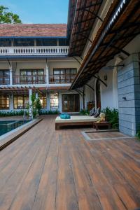 an outdoor patio with a wooden floor and a pool at Sanskreti in Cochin