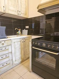 a kitchen with a black oven and a sink at Amfitrion on the Town in Gythio