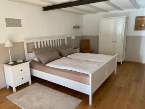 a bedroom with a white bed and a white cabinet at Haus Dekostüble in Münstertal