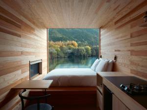 ein Schlafzimmer mit Blick auf einen See aus einem Fenster in der Unterkunft allbeans KOCHI in Kami