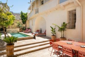 a patio with a table and chairs and a swimming pool at Palazzo Saetta in Nardò