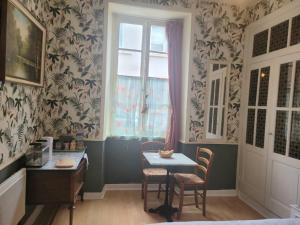 a dining room with a table and chairs and a window at 13 Bohemian Bienvenue B&B in Pontrieux