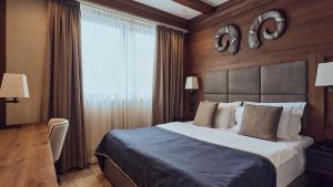 a bedroom with a large bed and a large window at Grey Family Hotel in Kopaonik +19 photos