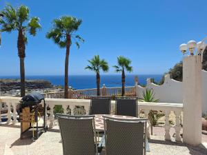 a table and chairs with palm trees and the ocean at Casa Mar II in Águilas