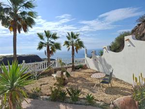 a garden with palm trees and a white fence at Casa Mar II in Águilas