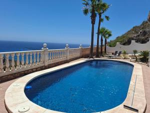 a swimming pool on a balcony with the ocean in the background at Casa Mar II in Águilas