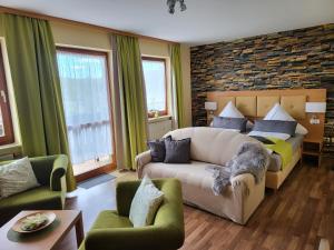 a living room with a couch and a bed at Hotel Seerose Garni in Nohfelden