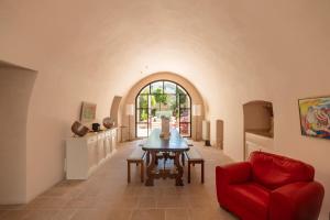 a living room with a table and a red chair at Palazzo Saetta in Nardò