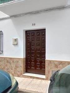 a garage with a brown door on a white wall at Casa Feria in Algodonales
