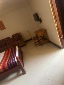 a small room with two beds and a table at Acactus Hotel in Kampala
