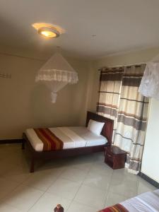 a small bedroom with a bed and a window at Acactus Hotel in Kampala