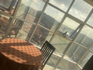 a table and chairs in a room with a large window at Acactus Hotel in Kampala
