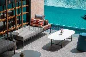 a patio with a couch and a table next to a pool at Antharas 1 Premier Suites Genting Highlands in Genting Highlands