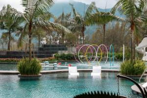 a swimming pool with chairs and a water park at Antharas 1 Premier Suites Genting Highlands in Genting Highlands